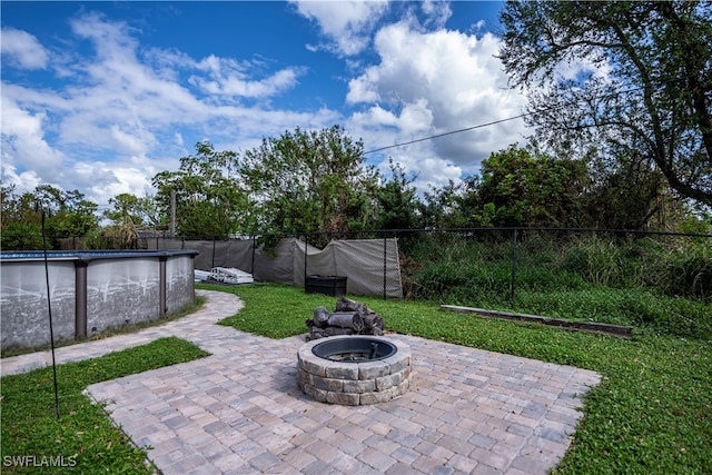 view of patio featuring a fenced in pool and a fire pit