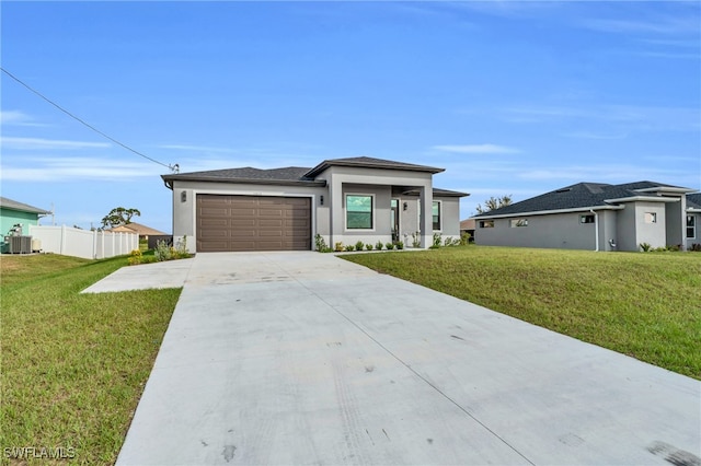 view of front of property featuring central AC, a garage, and a front lawn