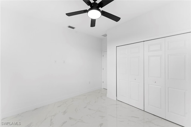 unfurnished bedroom with ceiling fan and a closet