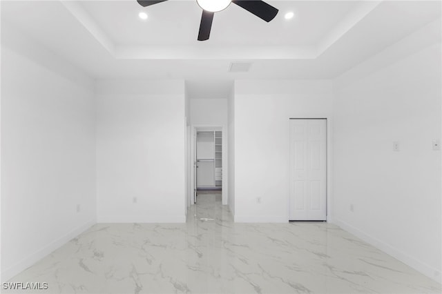 unfurnished room featuring ceiling fan and a tray ceiling