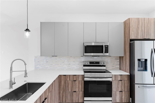 kitchen featuring sink, hanging light fixtures, stainless steel appliances, tasteful backsplash, and white cabinets