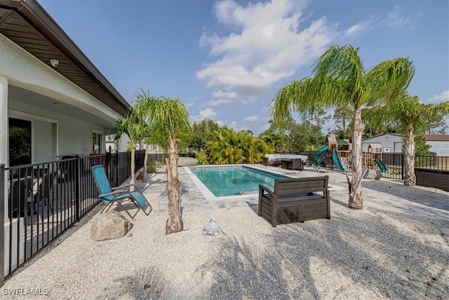 view of swimming pool with a playground and a patio area