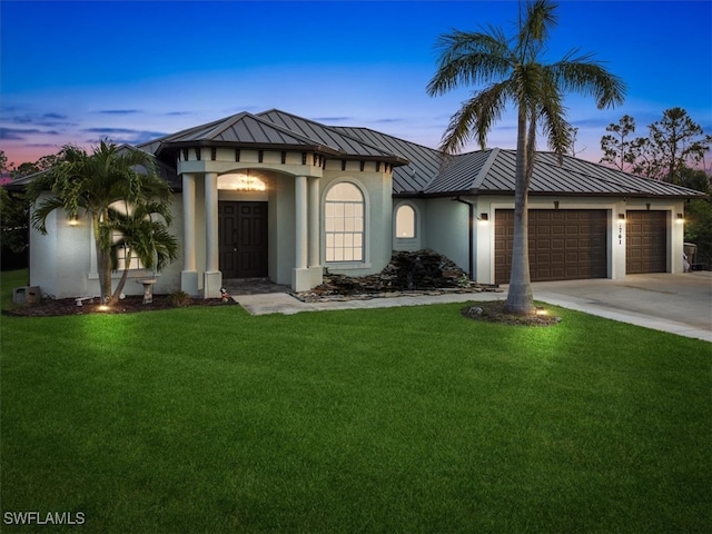 view of front of home featuring a garage and a yard