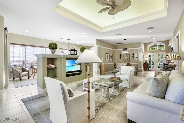 living room with ceiling fan, a healthy amount of sunlight, and a raised ceiling