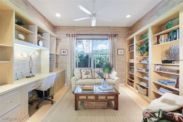 office space featuring light carpet, built in desk, and ceiling fan