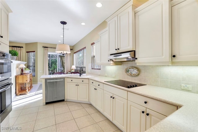 kitchen featuring light tile patterned flooring, backsplash, decorative light fixtures, sink, and stainless steel dishwasher