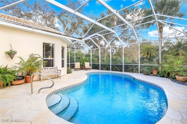 view of pool with glass enclosure and a patio