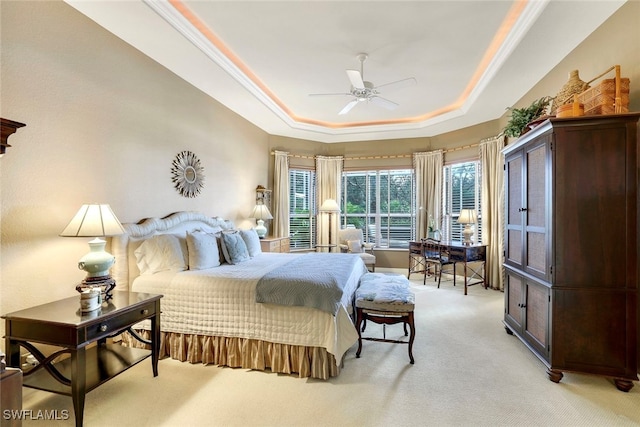 carpeted bedroom featuring ornamental molding, ceiling fan, and a raised ceiling