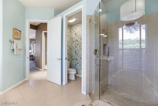 bathroom with tile patterned flooring, toilet, and a shower with door