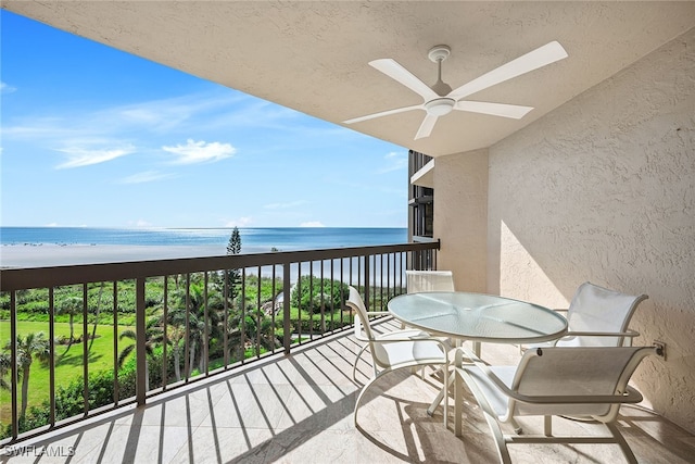 balcony with a beach view, a water view, and ceiling fan