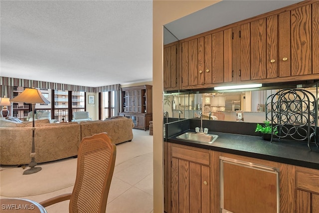 kitchen featuring light tile patterned floors, a textured ceiling, and sink