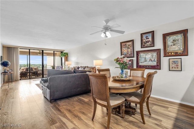 dining space with floor to ceiling windows, ceiling fan, and hardwood / wood-style flooring