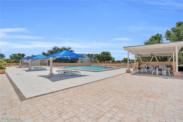 view of swimming pool with ceiling fan and a patio area