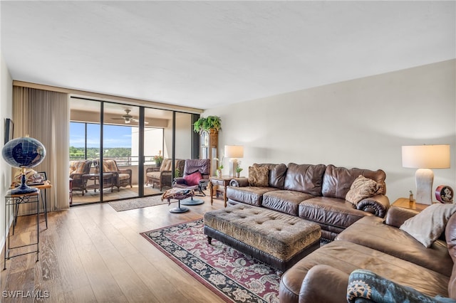 living room with floor to ceiling windows, ceiling fan, and light hardwood / wood-style flooring