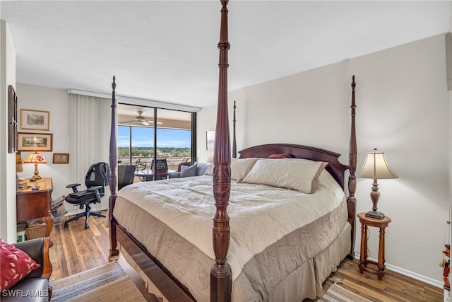 bedroom with access to exterior and hardwood / wood-style floors