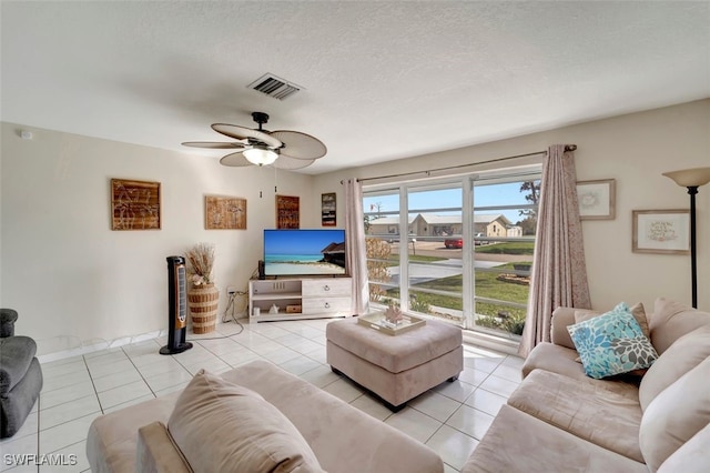 tiled living room with a textured ceiling and ceiling fan