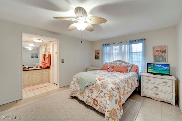 bedroom with ensuite bathroom, ceiling fan, sink, and light tile patterned flooring