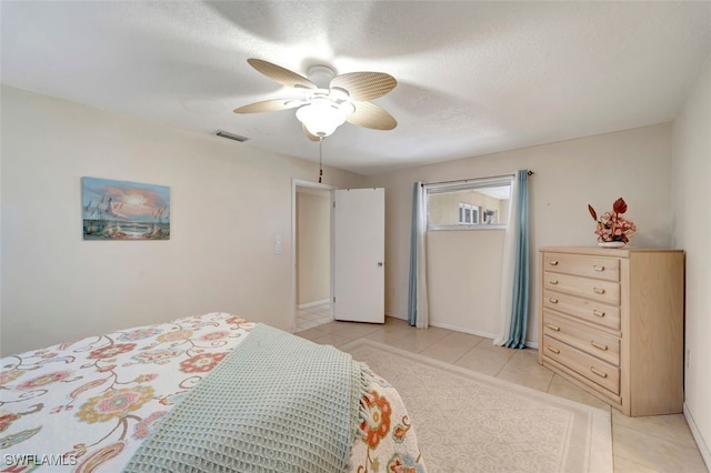 tiled bedroom featuring a textured ceiling and ceiling fan