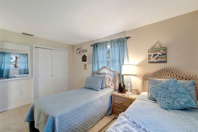 tiled bedroom featuring a closet and multiple windows