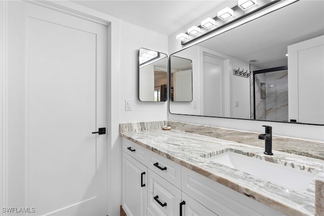 full bathroom with a stall shower, visible vents, and vanity