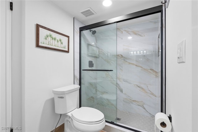 bathroom with toilet, a marble finish shower, and visible vents