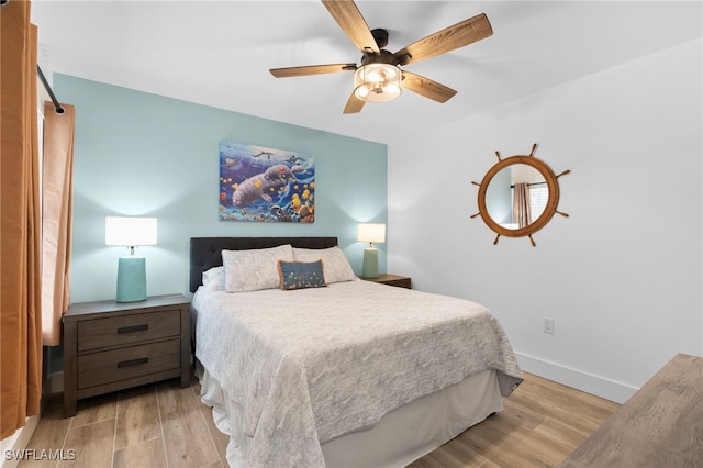 bedroom featuring ceiling fan, baseboards, and wood finished floors