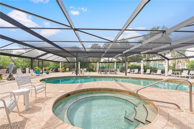 community pool with glass enclosure, a patio, and a hot tub