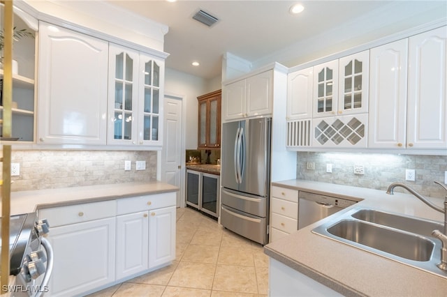 kitchen featuring white cabinets, light tile patterned flooring, sink, and appliances with stainless steel finishes