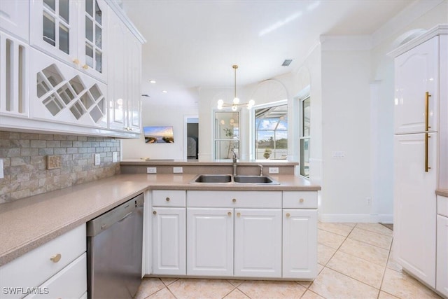 kitchen with sink, stainless steel dishwasher, light tile patterned flooring, white cabinetry, and decorative light fixtures