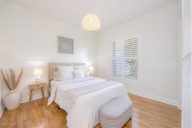 bedroom with hardwood / wood-style floors and crown molding