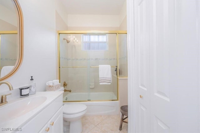 full bathroom featuring tile patterned flooring, shower / bath combination with glass door, toilet, and vanity