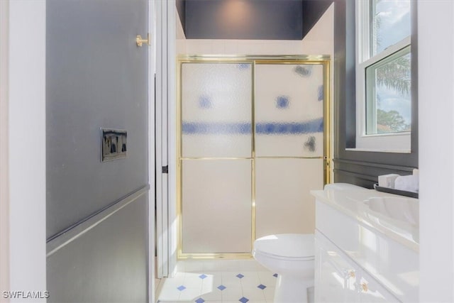 bathroom with vanity, toilet, and a shower with shower door