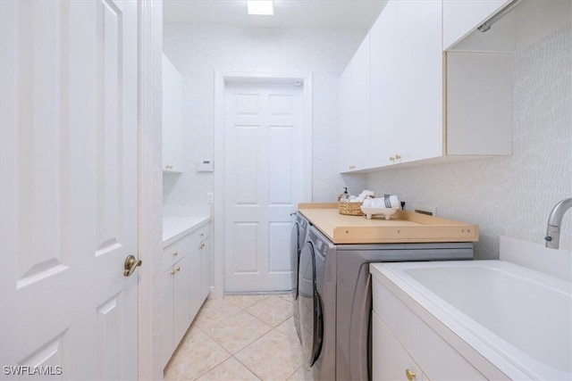 laundry area with cabinets, washing machine and dryer, sink, and light tile patterned flooring