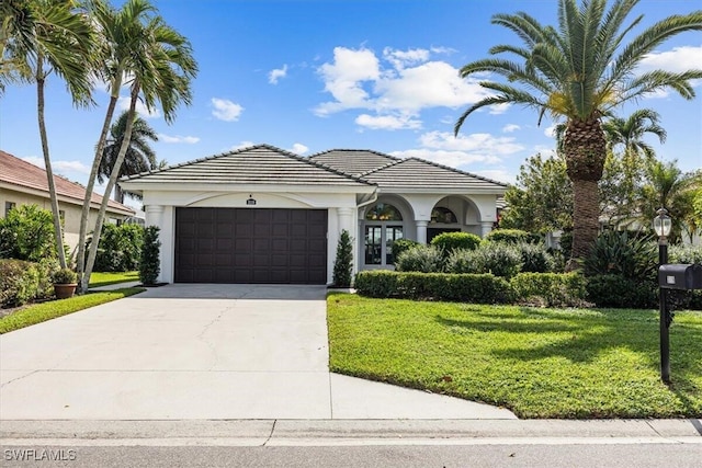 mediterranean / spanish-style house featuring a front lawn and a garage