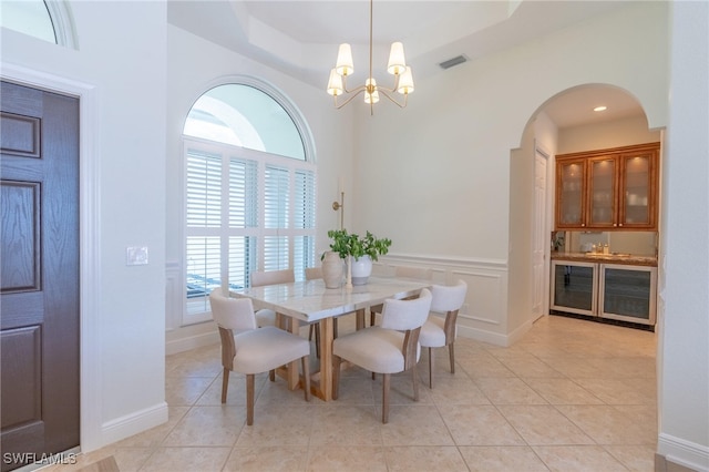 dining space with plenty of natural light, light tile patterned floors, and an inviting chandelier