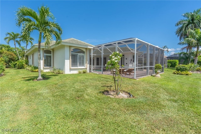 back of house featuring a swimming pool, glass enclosure, a yard, and a patio