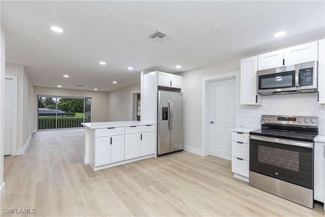 kitchen with light wood-type flooring, visible vents, white cabinetry, appliances with stainless steel finishes, and decorative backsplash