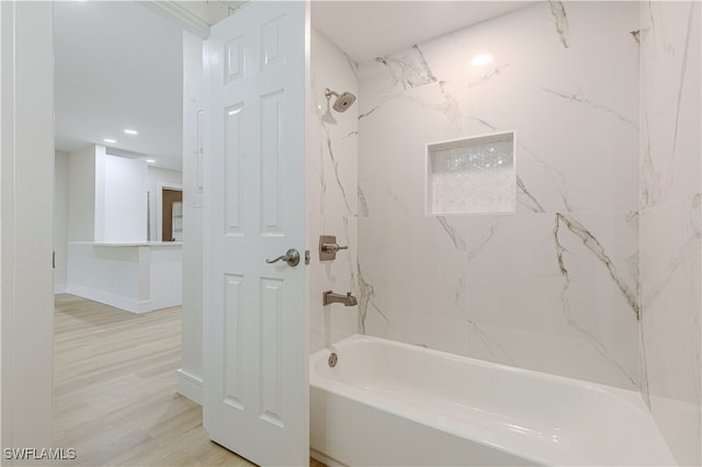 bathroom with recessed lighting, baseboards, bathing tub / shower combination, and wood finished floors