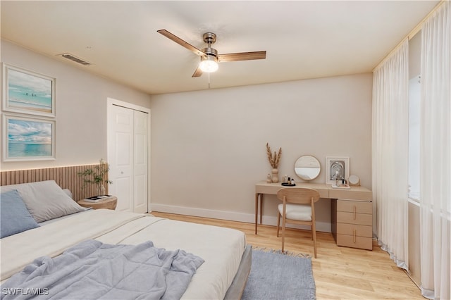 bedroom with ceiling fan, light wood-type flooring, and a closet