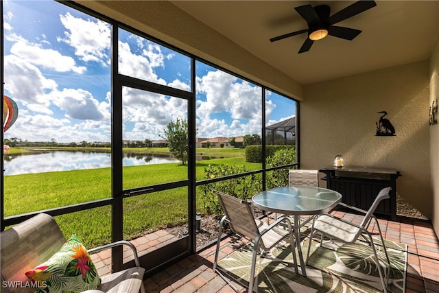 unfurnished sunroom with a water view and a ceiling fan