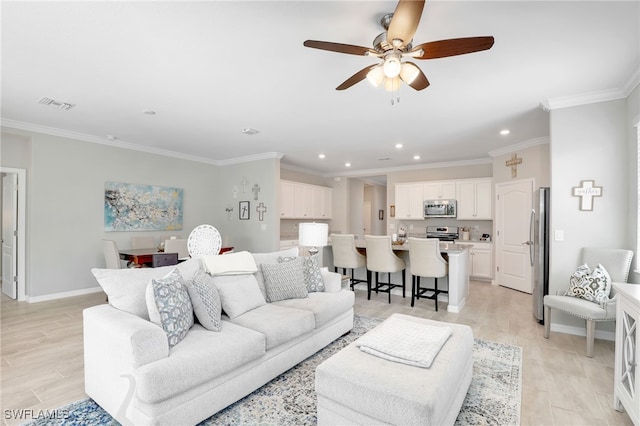 living room featuring ceiling fan, light wood-type flooring, and crown molding