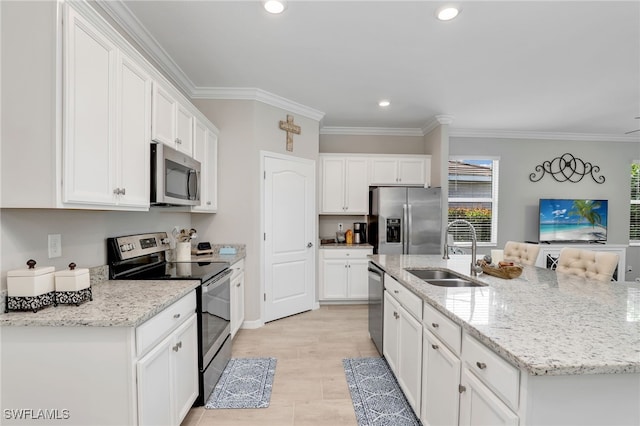 kitchen with appliances with stainless steel finishes, white cabinets, a center island with sink, and sink