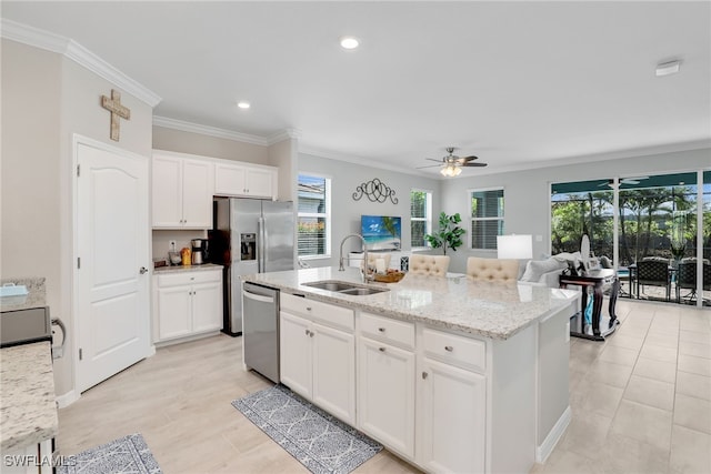 kitchen featuring stainless steel appliances, a kitchen island with sink, white cabinetry, and sink