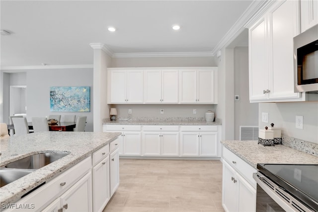 kitchen featuring ornamental molding, white cabinetry, light stone counters, and sink