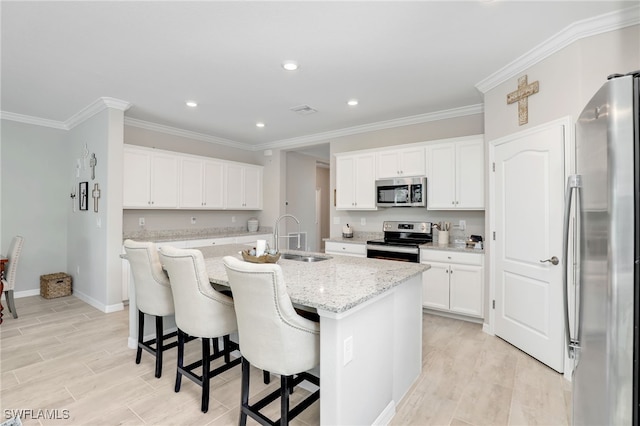 kitchen with sink, white cabinetry, light stone countertops, a center island with sink, and appliances with stainless steel finishes