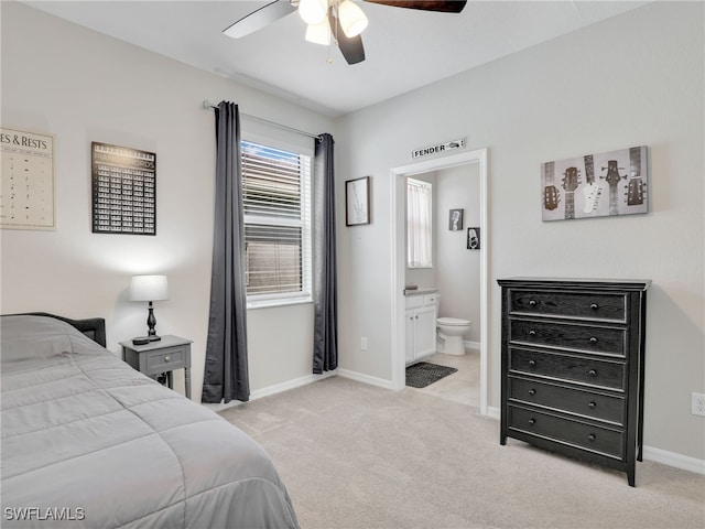 carpeted bedroom with ensuite bathroom and ceiling fan