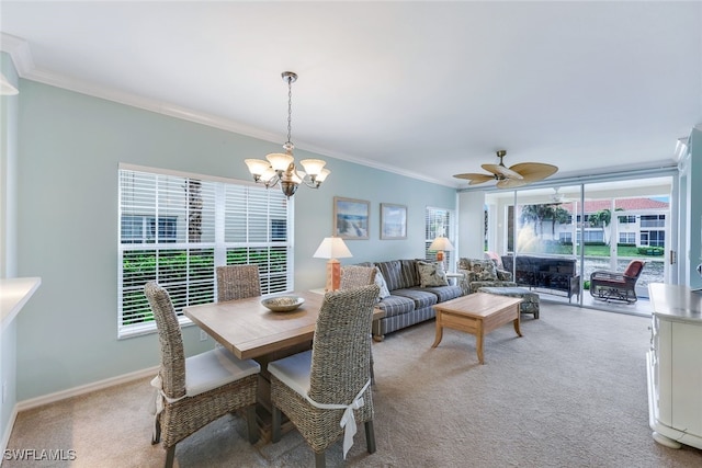 dining area featuring light carpet, ceiling fan with notable chandelier, and ornamental molding