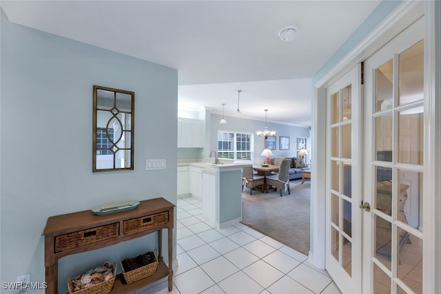 interior space with sink, french doors, light carpet, and an inviting chandelier