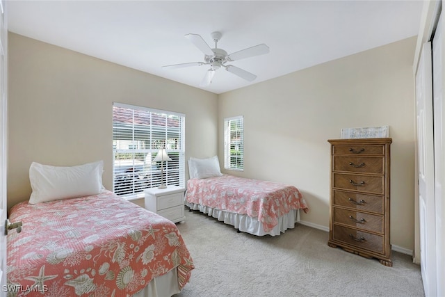 carpeted bedroom with ceiling fan, a closet, and multiple windows