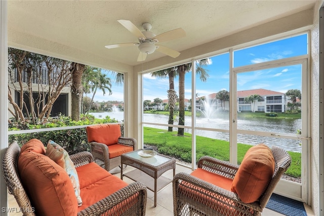 sunroom / solarium featuring ceiling fan and a water view